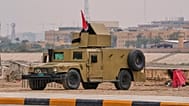 تم نشر مركبة هامفي مدرعة تابعة للجيش العراقي بالقرب من ضفاف نهر دجلة لحماية "المنطقة الخضراء" المحصنة التابعة للسفارة الأمريكية في بغداد، يوم السبت 14 مارس 2026. (صورة من وكال