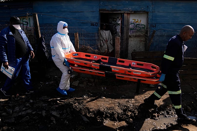 Police officers carry stretchers after a mass shooting at an informal settlement near Johannesburg, 10 June, 2026