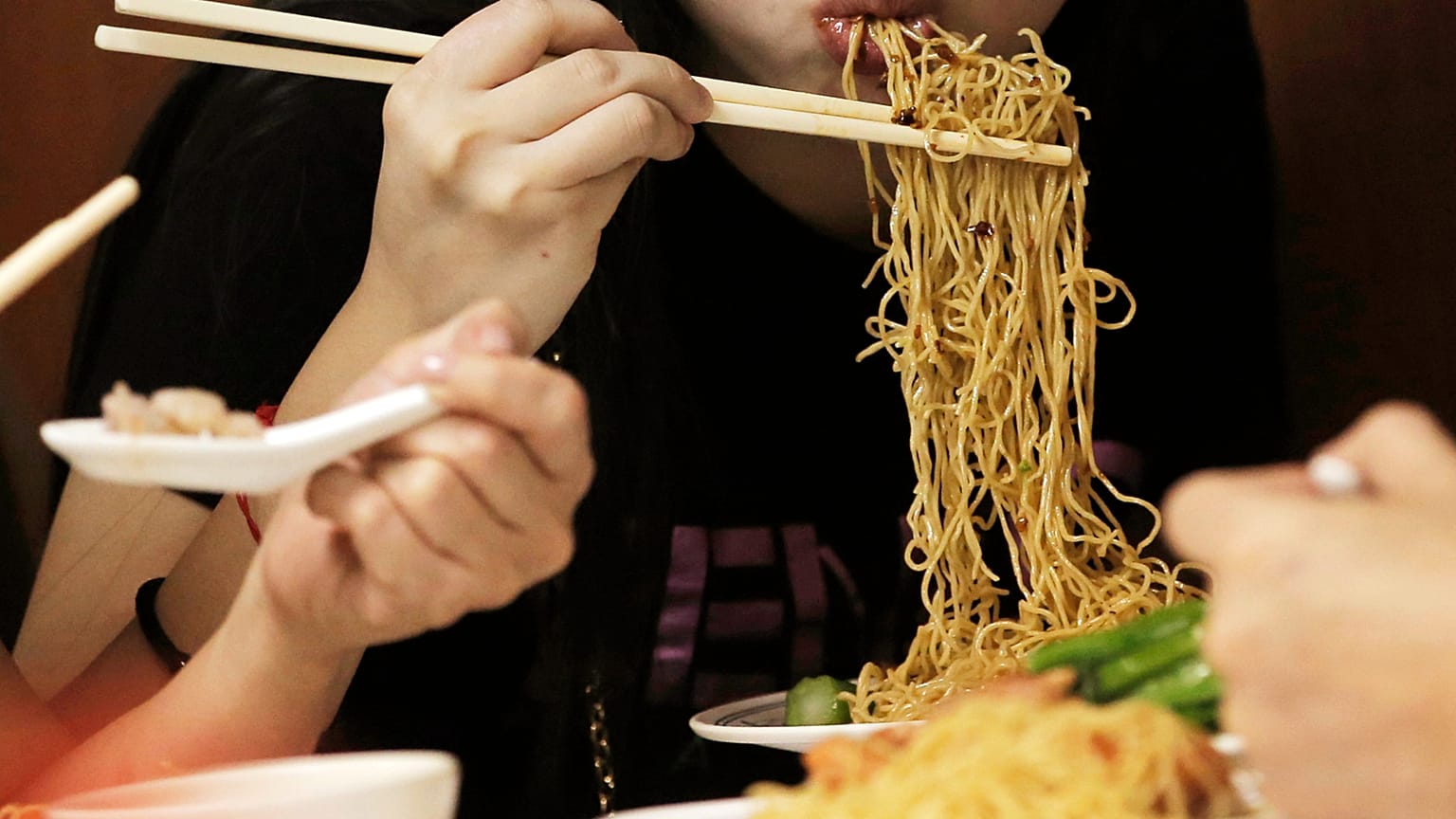 يتناول العملاء المعكرونة في متجر Wing Wah Noodle Shop في هونغ كونغ، في 12 يوليو 2018. (AP Photo/كين تشيونغ، ملف)