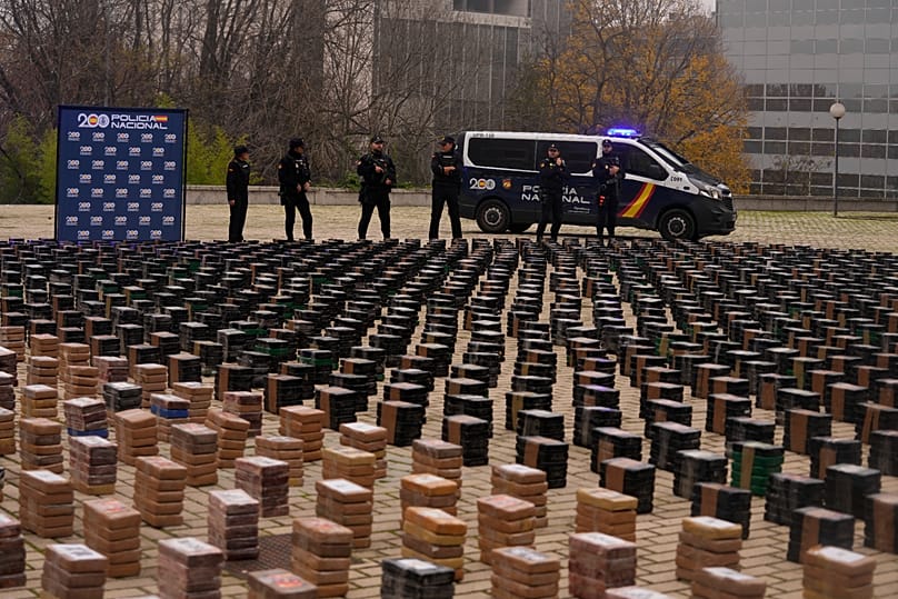Agentes da polícia junto a parte de uma apreensão de 11 toneladas de cocaína, exposta no pátio de uma esquadra em Madrid, Espanha, terça-feira, 12 de dezembro de 2023