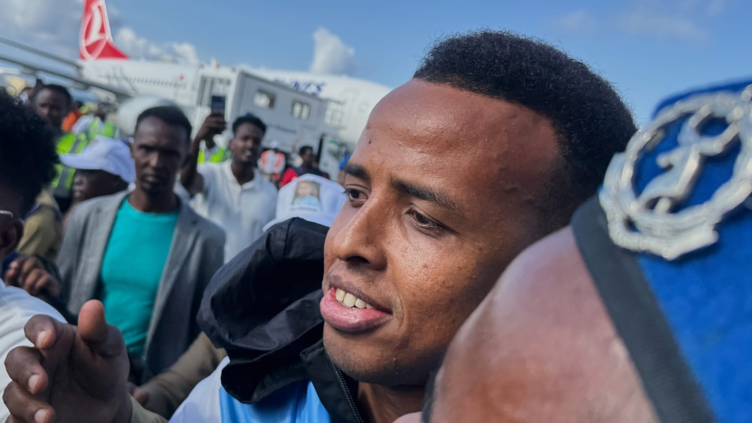 Referee Omar Artan, who was denied entry to the United States, is welcomed by supporters upon his arrival 