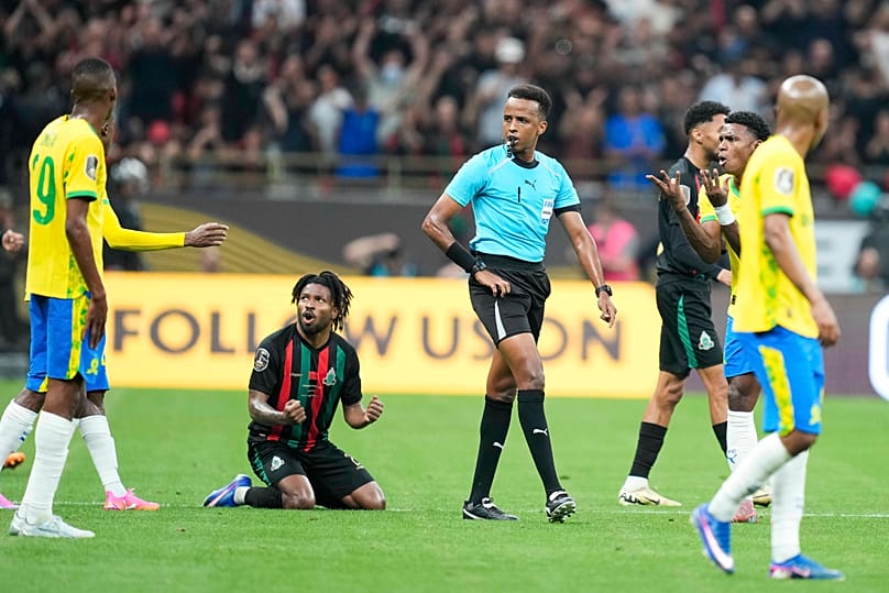 Referee Omar Artan, center, of Somalia, signals a penalty during the CAF Champions League final soccer match between AS FAR Rabat and Mamelodi Sundowns, in Rabat, Morocco.