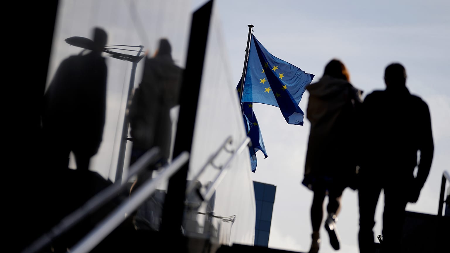 A couple walk past the European Commission on 26 October, 2021.
