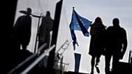 A couple walk past the European Commission on 26 October, 2021.