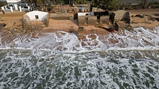 FILE - Waves lap the beach where remains of Afeli Bernice Adzo's family home stand after it was destroyed by coastal erosion in Avegadzi, Ghana, March 5, 2025.