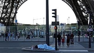 File - A homeless sleeps just next to the Eiffel Tower Wednesday, 10 Apri 2024 in Paris. 