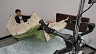 Trainer and robot arms fold a mattress during a media tour in Beijing E-Town, China, on May 29, 2026.