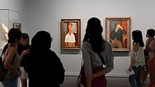 People view paintings, left to right; Gaston Modot and The Young Apprentice, both by Amedeo Modigliani, on display as a part of the Rendez-vous à Paris exhibition
