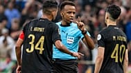 Referee Omar Artan, center, of Somalia, is confronted by players after calling a penalty kick during the CAF Champions League final soccer match.