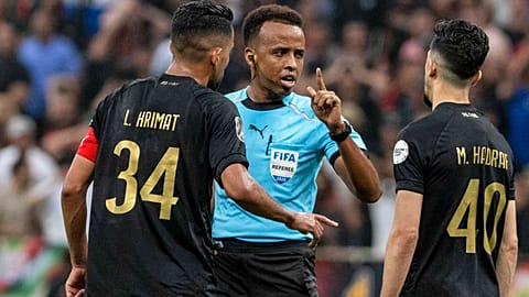 Referee Omar Artan, center, of Somalia, is confronted by players after calling a penalty kick during the CAF Champions League final soccer match.