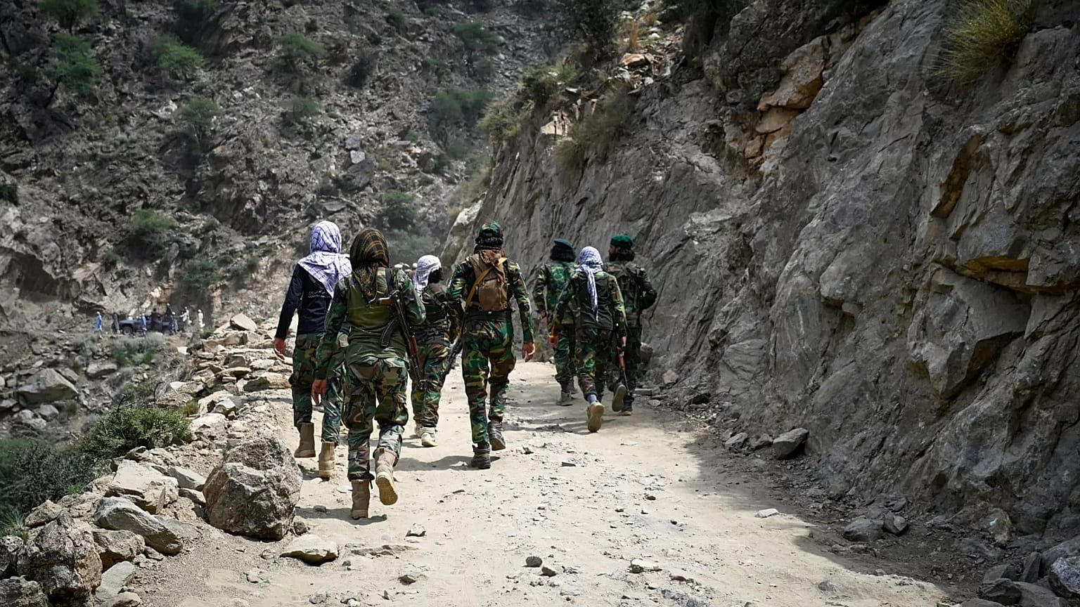 Taliban soldiers walk along a dirt road in eastern Kunar province, 2 September, 2025