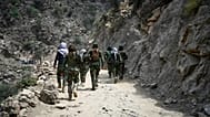 Taliban soldiers walk along a dirt road in eastern Kunar province, 2 September, 2025