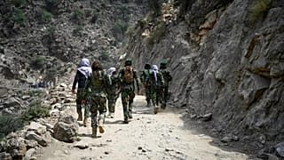 Taliban-Kämpfer gehen auf einer Schotterstraße in der ostafghanischen Provinz Kunar, am zweiten September 2025.