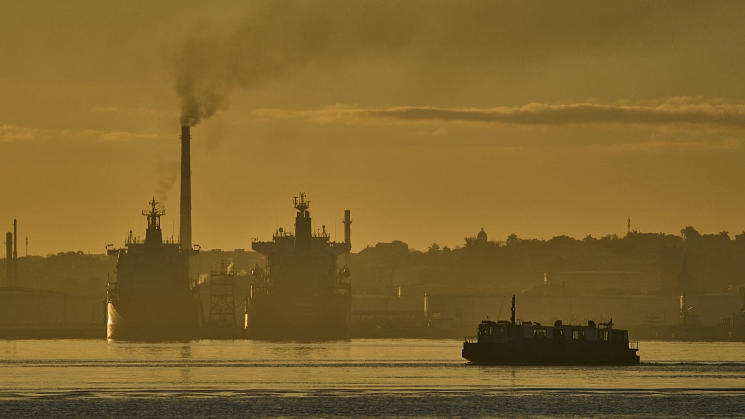 Un ferry cruza la bahía de La Habana pasando por la refinería de petróleo Nico López, donde hay buques cisterna anclados en la bahía de La Habana, Cuba, el 24 de marzo de 2026