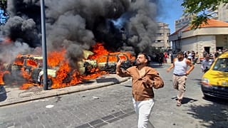  People run in front of burned cars that were attacked in an Israeli airstrike in the southern port city of Sidon, Lebanon, Wednesday, June 10, 2026.