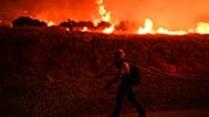 Архивное фото: Пожарный наблюдает за огнем, вызванным пожаром Hughes, у озера Кастейк в городе Кастейк, штат Калифорния, 22 января 2025 года.