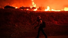 ARCHIVES - Un pompier surveille les flammes provoquées par l’incendie Hughes le long du lac Castaic, à Castaic, en Californie, le 22 janvier 2025.