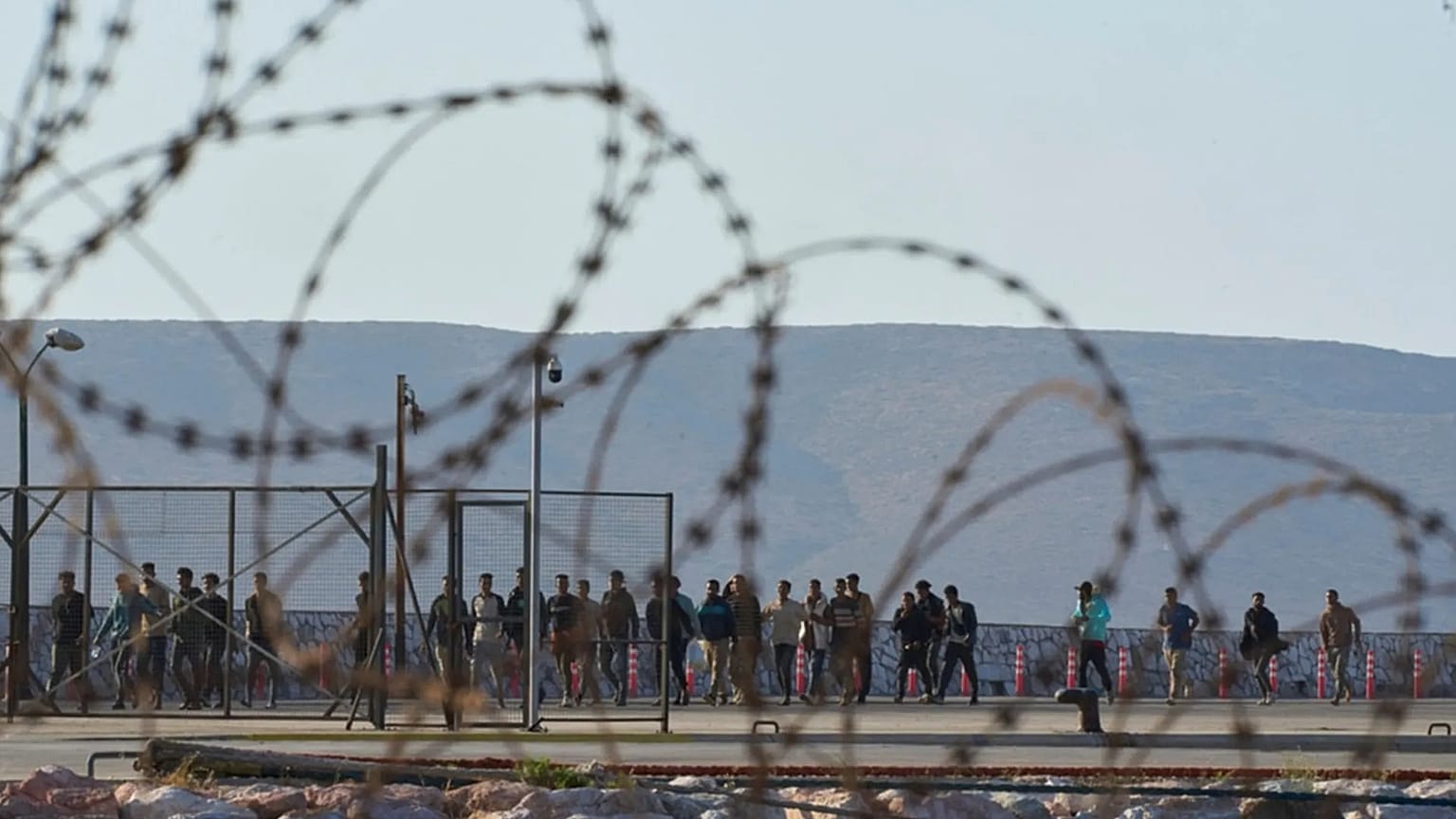 FILE - Migrants rescued south of Crete walk after their arrival at the the port of Lavrio, Greece, on July 10, 2025
