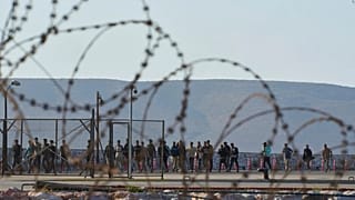 FILE - Migrants rescued south of Crete walk after their arrival at the the port of Lavrio, Greece, on July 10, 2025