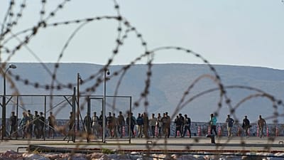 ARCHIVIO - Migranti soccorsi a sud di Creta camminano dopo il loro arrivo al porto di Lavrio, in Grecia, il 10 luglio 2025.
