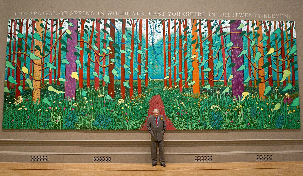 British artist David Hockney stands before one of his paintings of the East Yorkshire landscape at The Royal Academy of Arts in Piccadilly, London, 16 January 2012.