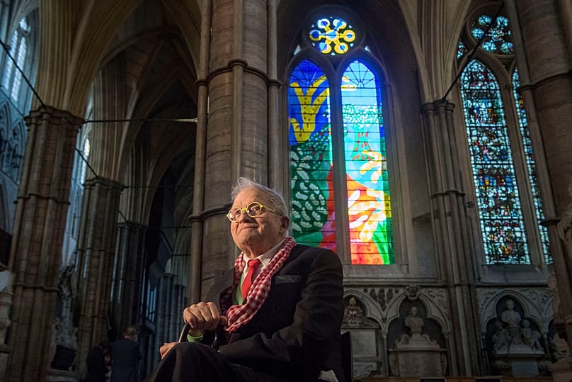 David Hockney sits in front of The Queen's Window, a new stained glass window at Westminster Abbey, London, designed by David Hockney, 2018. 
