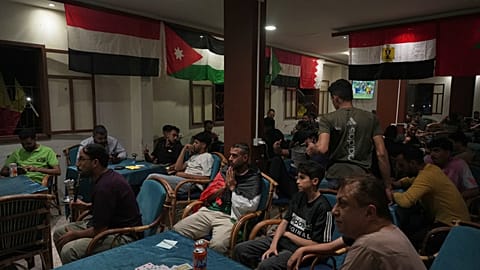 Aficionados al fútbol ven la retransmisión del partido inaugural del Mundial entre México y Sudáfrica en una cafetería local de la Franja de Gaza