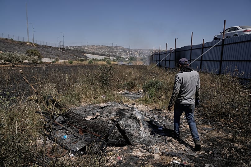 رجل فلسطيني يتفقد موقع هجوم المستوطنين الإسرائيليين في بلدة حوارة بالضفة الغربية، نابلس، السبت 6 يونيو 2026. (AP Photo/مجدي محمد)