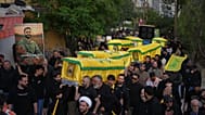 مشاركون يحملون نعوش مقاتلين من حزب الله خلال تشييع جماعي في بلدة كفّرصير جنوب لبنان، في 21 أبريل 2026.
