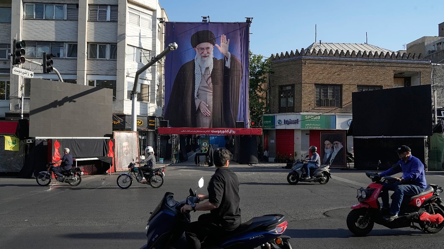 دراجات نارية تسير بالقرب من المنزل الذي قُتل فيه المرشد الأعلى الإيراني الراحل علي خامنئي، الذي يظهر على لافتة، في غارات أمريكية وإسرائيلية في 28 فبراير في طهران السبت 6 يونيو