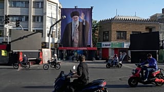 دراجات نارية تسير بالقرب من المنزل الذي قُتل فيه المرشد الأعلى الإيراني الراحل علي خامنئي، الذي يظهر على لافتة، في غارات أمريكية وإسرائيلية في 28 فبراير في طهران السبت 6 يونيو
