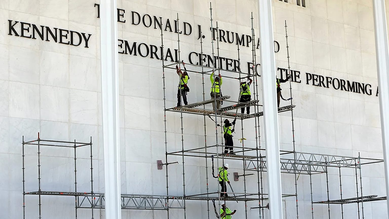 Workers construct scaffolding below the John F. Kennedy Center for the Performing Arts sign in Washington, 12 June, 2026