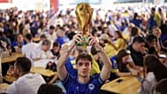 A Bosnian fan waves an inflatable World Cup trophy at a fan zone in Sarajevo, 12 June 2026