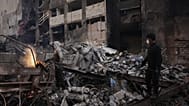 عامل يقطع خردة معدنية بينما تتطاير الشرر وسط الحطام في موقع مبنى دمر في غارة جوية إسرائيلية الأربعاء الماضي في وسط بيروت،