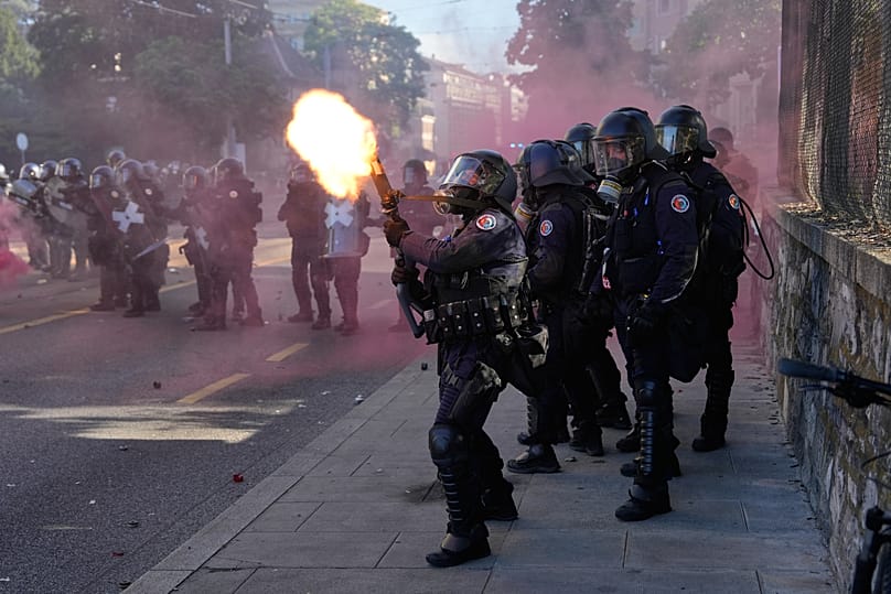 Un policier lance une grenade lacrymogène lors d'une manifestation anti-G7 à Genève, en Suisse, le dimanche 14 juin 2026, à la veille du sommet du G7 prévu du 15 au 17 juin