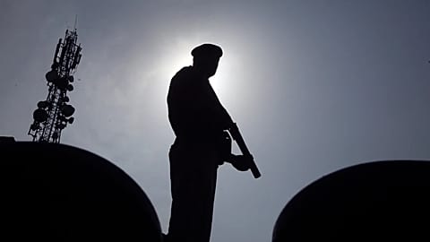 Agente da polícia fica em silhueta enquanto monta guarda em Peshawar, 5 de agosto de 2023