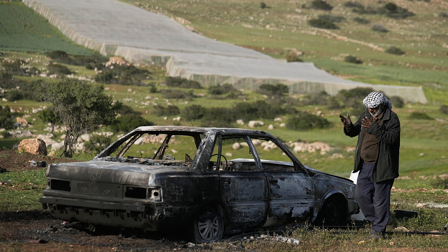 صورة أرشيفية- يتفقد أحد السكان سيارة أضرم فيها مستوطنون إسرائيليون النار، بحسب الهلال الأحمر الفلسطيني، في قرية تياسير بالضفة الغربية، قرب طوباس