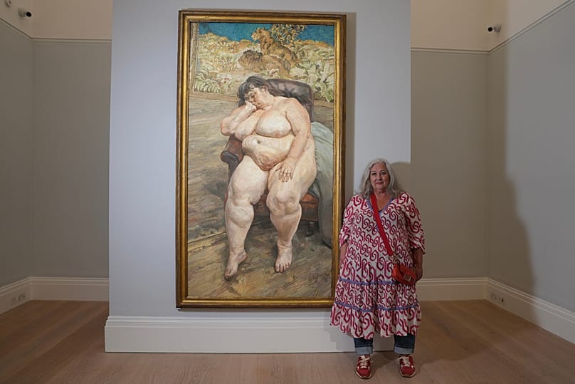 Sue Tilley, Modell des britischen Malers Lucian Freud, posiert vor Freuds Bild von ihr mit dem Titel "Sleeping by the Lion Carpet".