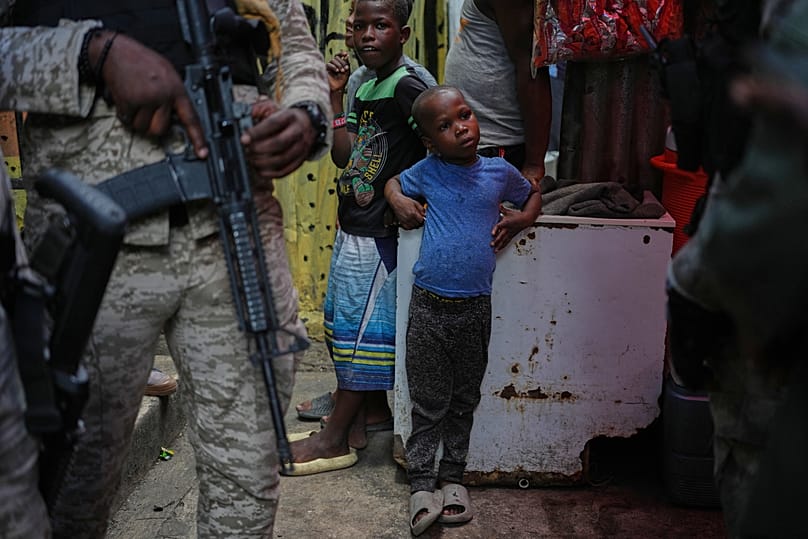 Children stand next to police officers in Port-au-Prince, 27 April, 2026