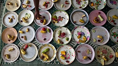 مردی در یک مسجد در شهر گواهاتی هند، میوه‌ها و خوراکی‌های شور را روی بشقاب‌ها می‌چیند؛ عکس تزئینی است. جمعه ۲۴ ژوئن ۲۰۱۶.