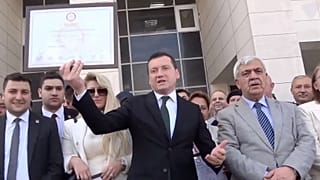 Silivri Belediye Başkanı Bora Balcıoğlu (ortada) 2024 seçimlerinin ardından belediye binasının girişinde mazbatasını tutarken