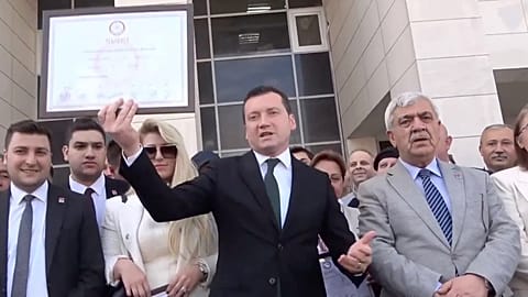 Silivri Belediye Başkanı Bora Balcıoğlu (ortada) 2024 seçimlerinin ardından belediye binasının girişinde mazbatasını tutarken