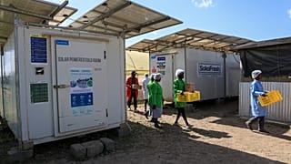 Workers carry fresh herbs from Soko Fresh solar-powered cold rooms at Citadel Agri Merchants in Kitengela, Kajiado County, Kenya