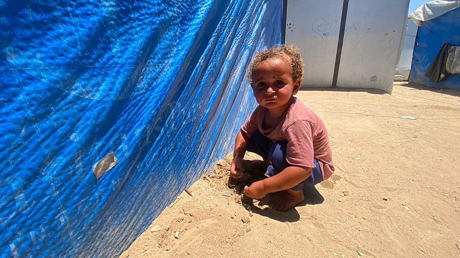 طفل فلسطيني خارج خيمة للنازحين وسط قطاع غزة