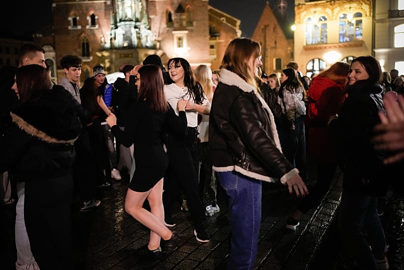 Fiatalok táncolnak a krakkói piactéren
