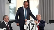 German Chancellor Friedrich Merz, center, presents U.S. President Donald Trump