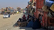 Afghan refugees sit beside trucks loaded with their belongings on the Pakistan-Afghanistan border, 29 October, 2025