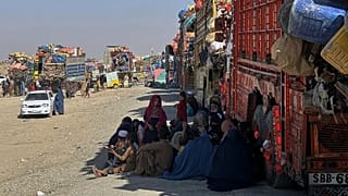 Afghan refugees sit beside trucks loaded with their belongings on the Pakistan-Afghanistan border, 29 October, 2025