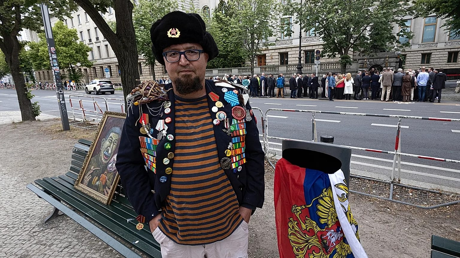 Semyon Skrepetsky poses for a photo with one of his paintings near the Russian Embassy in Berlin, 12 June, 2026