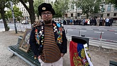 Semyon Skrepetsky poses for a photo with one of his paintings near the Russian Embassy in Berlin, 12 June, 2026